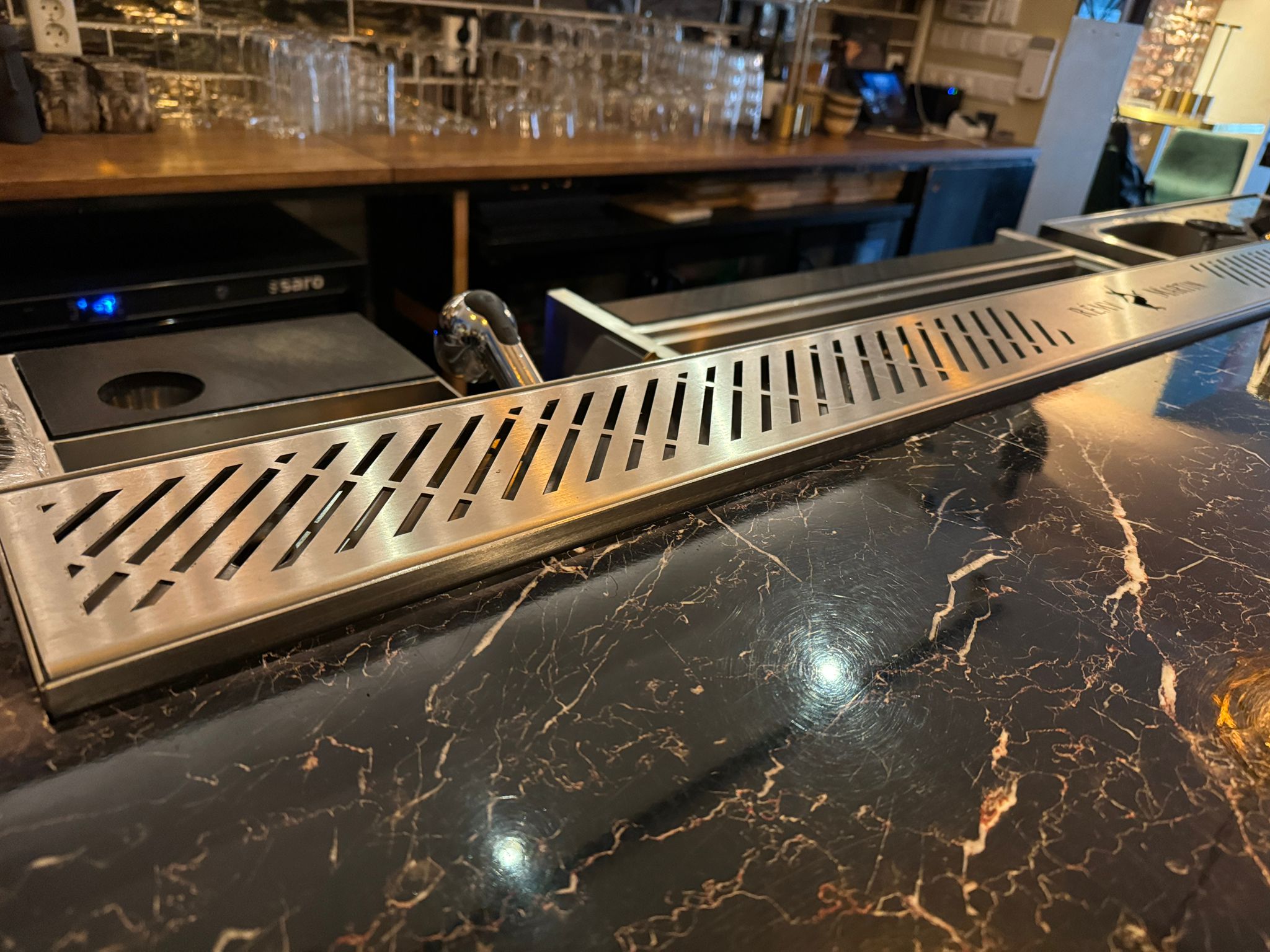 Stainless steel drink rail installed on bar - drain detail